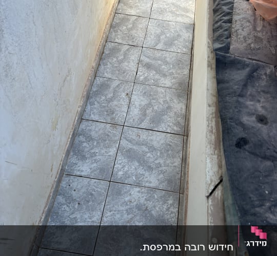 רצפת אריחים אפורה עם מכסה ביוב עגול